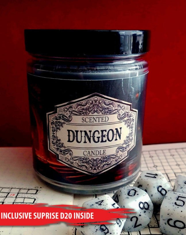 A dark glass jar candle labeled 'Scented Dungeon Candle' with a black lid, set on a tabletop with dice in front against a red background.