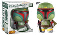 A Boba Fett plush figure shown next to its retail box. The figure has green armor with red, black, yellow, and gray details, and is posed with a blaster.