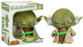 Yoda plush figure by Suko for Fabrikation, shown both inside its window box packaging and as an unpackaged figure holding a green lightsaber. The box features 'Fabrikation' and 'Star Wars' branding.