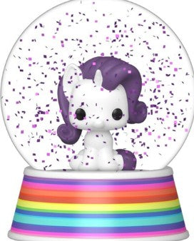 A collectible snow globe featuring a small white cartoon unicorn with purple hair, surrounded by purple confetti inside a clear sphere, set on a rainbow-striped base.