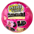 A pink spherical vinyl record toy labeled 'MGA's Mini Verse Real Music Vinyl' with album-cover style graphics and a small hand peeling back a sticker on the left side.