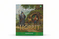 Magic: The Gathering The Hobbit Prerelease card box cover, featuring artwork of a wizard and a hobbit in front of a hobbit house, with the Magic logo and 'The Hobbit' title.