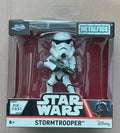 Star Wars Metalfigs Die-Cast Stormtrooper action figure in its original retail packaging, featuring a white stormtrooper holding a blaster against a red background.