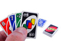 A close-up of a hand holding several UNDO card game cards, with two additional cards and a UNDO box visible on a plain white background.